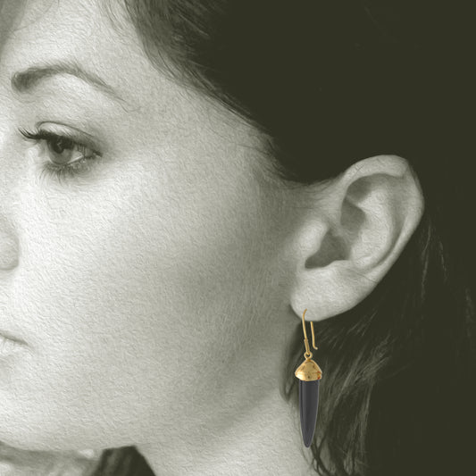 Earrings by Susan Crow Studio, Bullet shaped genuine Black Jet Gemstones  in a hand carved and cast recycled 14kt yellow gold drop earrings, one of a kind. 1" long. Shown on Model