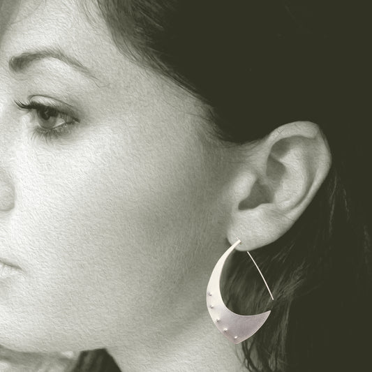 The Aubergine Sterling Silver Hoop Earrings are the perfect size. When you put them on, the only time you will notice them is when you look in the mirror, because they are surprisingly lightweight. Fabricated from recycled sterling silver.  FEATURES  º Hand fabricated in recycled sterling silver  º Soft brushed cashmere finish  º 2" total length. Shown on a model.