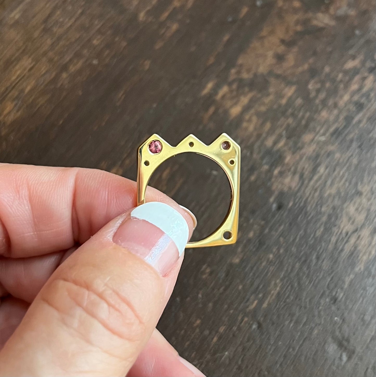 The Crown shaped Flat Ring: º Wear alone or stacked with your favorite stacking bands  º Hand-carved and cast in 14kt recycled gold.   º 2 flush set dark pink tourmalines  º Comfortable inside fit  º Cashmere finish.  º Available to ship in a size 7.