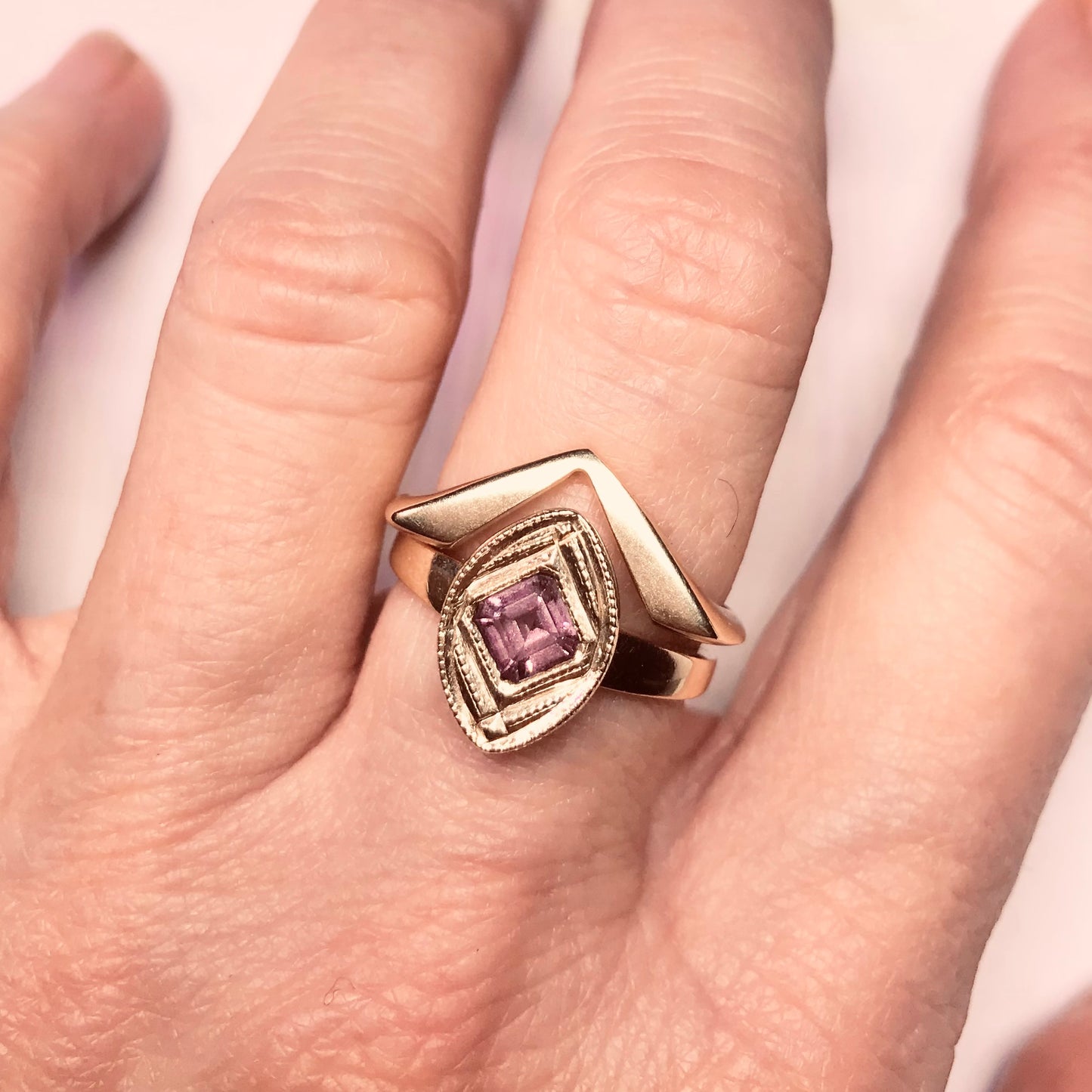 14kt yellow gold ring with a square cut Rhodolite Garnet flush set at a right angle into the center of the ring. Size 7 Shown on a hand stacked with our Viceroy 14kt yellow gold ring.