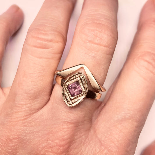 14kt yellow gold ring with a square cut Rhodolite Garnet flush set at a right angle  into the center of the ring. Size 7 Shown on a hand stacked with our Viceroy 14kt yellow gold ring.
