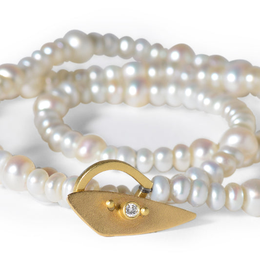 The Pearl Toggle Necklace consists of 17” of varying sized freshwater pearls hand knotted with silk thread. It’s handmade one of a kind toggle clasp is highlighted with a round bezel set diamond.
