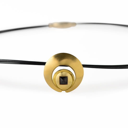The Moon Pendant has a 4mm genuine square cut Black Spinel gemstone and the multiple circle dome shaped pieces make up the pendant . it is approximately 1" in diameter and hangs from a 17” multi strand black ruthenium plated sterling silver collar with a 14kt gold barrel clasp.