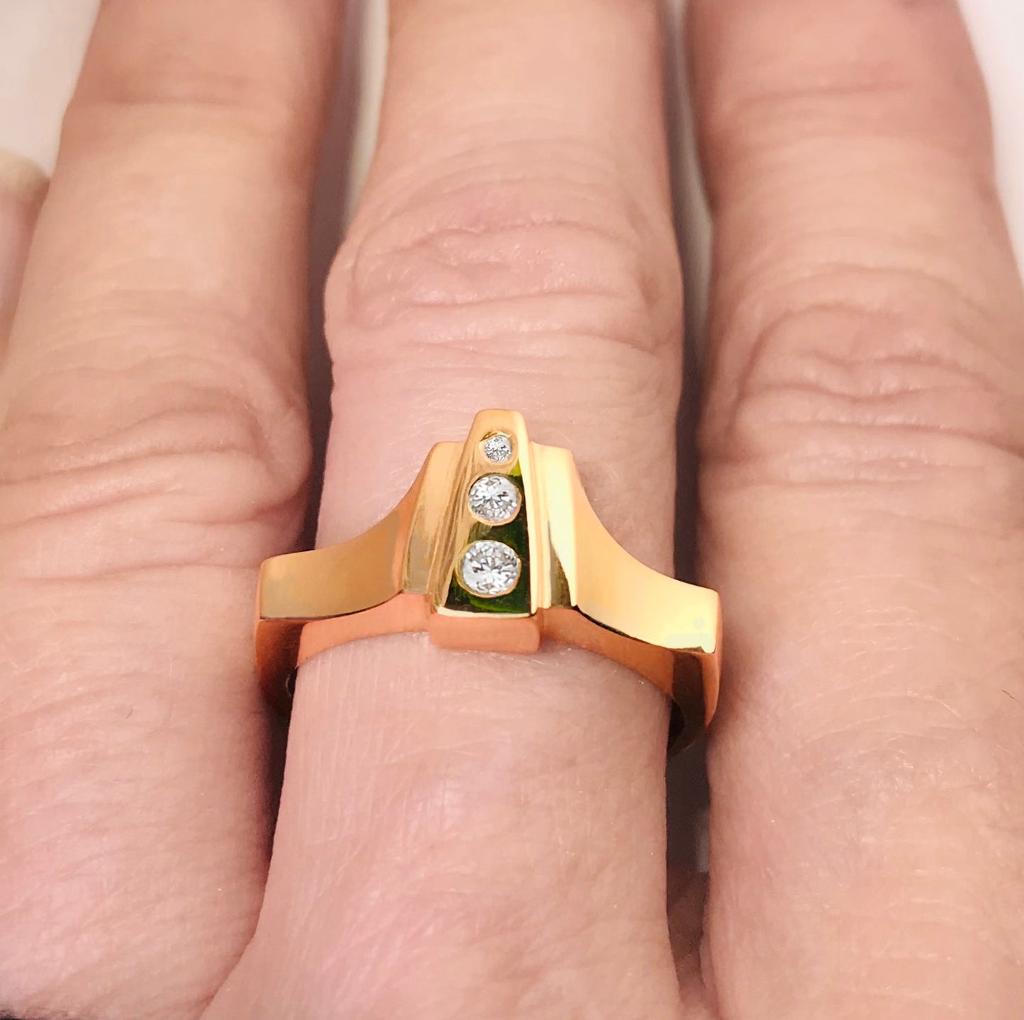Lliad Ring crafted out of 18kt Fairmined gold and reclaimed white round diamonds has a hint of historical design with a modern spin. When you look down at your hand, you will fall in love each time with the diamond sparkle and spacial planes. Wear it on your middle finger or ring finger for a bold graphic statement. FEATURES: º Hand carved and cast in 18kt certified Fairmined Gold. º Comfortable fit with a flat bottom shank º Soft cashmere finish º Original design that stacks easily with other rings.