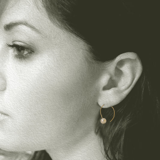 Simple 18kt and pearl open hoop earring. 7mm round pearls 1 on each hoop earring 1.25" x .5". Shown on model.