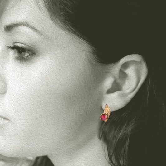 Our Pomegranate Post Earrings aren't really major, but will make you feel that way. Rose colored 5.5mm Rhodolite Garnets&nbsp;are bezel set in our 14kt gold and post earrings – are perfect when you want a post earring that has more presence than a smaller stud earring.
Shown on a model.