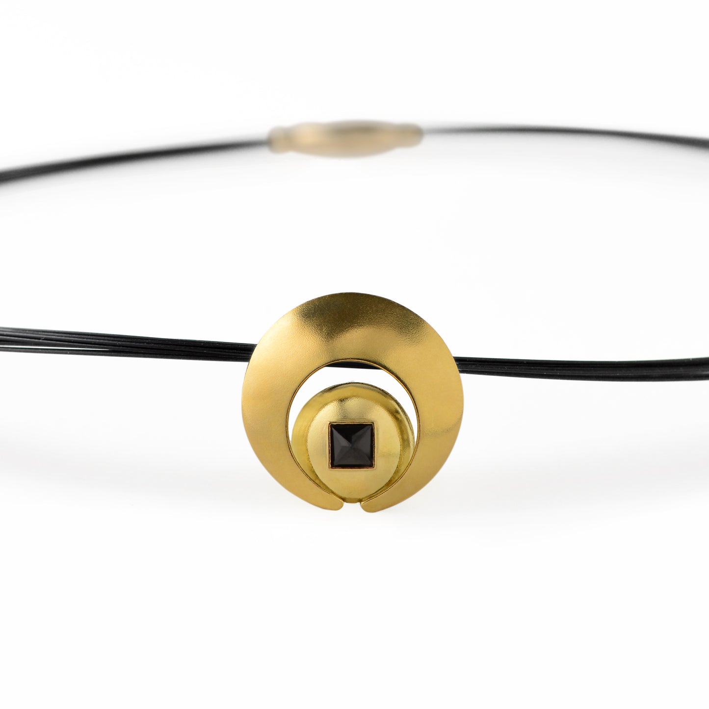 The Moon Pendant has a 4mm genuine square cut Black Spinel gemstone and the multiple circle dome shaped pieces make up the pendant . it is approximately 1" in diameter and hangs from a 17” multi strand black ruthenium plated sterling silver collar with a 14kt gold barrel clasp.