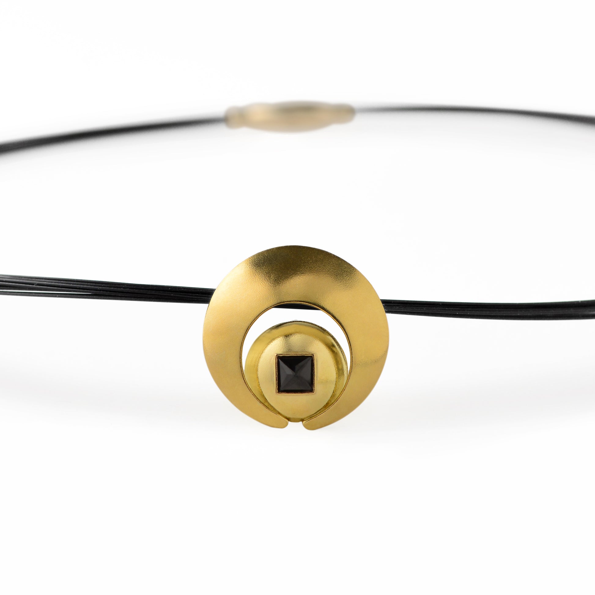 The Moon Pendant has a 4mm genuine square cut Black Spinel gemstone and the multiple circle dome shaped pieces make up the pendant . it is approximately 1" in diameter and hangs from a 17” multi strand black ruthenium plated sterling silver collar with a 14kt gold barrel clasp.