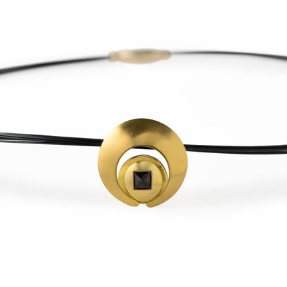 The Moon Pendant has a 4mm genuine square cut Black Spinel gemstone and the multiple circle dome shaped pieces make up the pendant . it is approximately 1" in diameter and hangs from a 17” multi strand black ruthenium plated sterling silver collar with a 14kt gold barrel clasp.