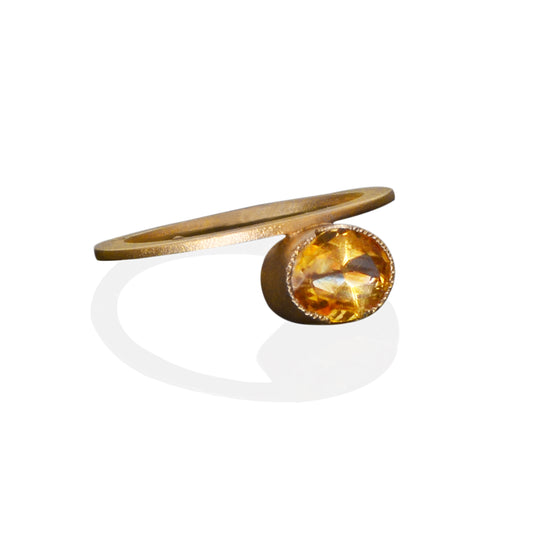 oval cut golden citrine gemstone set east west in a 14kt yellow gold bezel. The ring is 2mm wide by 3mm high. Modern, one of a kind design.