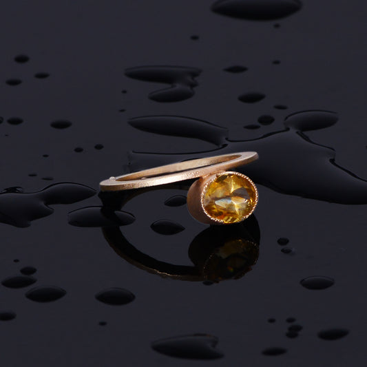 oval cut golden citrine gemstone set east west in a 14kt yellow gold bezel. The ring is 2mm wide by 3mm high. Modern, one of a kind design.