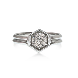 Art Deco inspired hexagon shaped engagement and wedding ring set. Milgrain edged hexagon shape holds the .50CT diamond or 5mm sapphire. Matching 1.5mm wedding ring sits next to engagement ring.