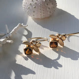 Leaf earrings made from 14kt yellow gold with cushion cut amber colored citrine. .75” long with circle shaped French wire.