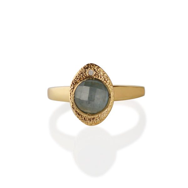 Our Blue-Sorbet Sapphire and Gold Ring is a blend of sculptural and textural elements.   º One-of-a-kind  º Made from  14kt Fairmined yellow gold  º Responsibly Sourced rose-cut 5.5mm round blue sapphire is hand set in a bezel. A 2mm round reclaimed diamond is flush set.  º Soft cashmere brushed finish  º Hand carved and cast in Minnesota  º Available to ship in a size 7.